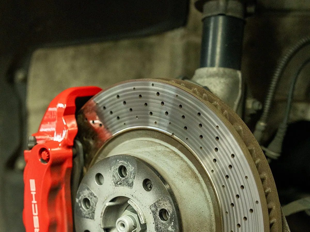 Bremsscheibe und roter Bremssattel eines Fahrzeugs auf der Hebebühne